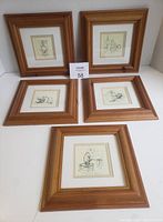 Five framed Winnie-the-Pooh prints arranged on a white surface.