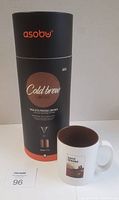 Asobu Cold Brew Coffee insulated portable brewer in original box with Starbucks Cafe Verona mug next to it.