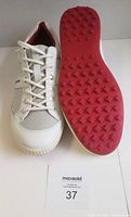 Top and sole view of men's white Ecco golf shoes with red outsole showing traction pattern and laces, proving condition and style