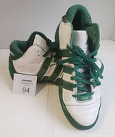 Pair of Adidas basketball shoes placed side by side showing front and side views with laces tied.