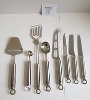 All 8 Rosle kitchen utensils laid out in a row on white background, showing entire set with handles and utensil heads clearly visible.