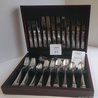 Open wooden chest with full cutlery service in Triste pattern