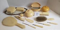 Full set arranged on mirrored tray with multiple French Ivory vanity pieces including hand mirror, brush, comb, covered boxes, jar, nail buffer, and manicure tools.