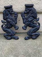 Both cast iron lion mounts side by side showing overall shape and condition