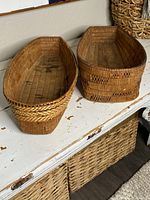 Two Salish cradle baskets side by side showing shape, weaving and coloration