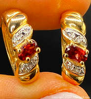 Front view of both earrings showing gold gilt surface, central garnets and diamond-set marquise segments