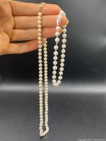 Necklace and bracelet held in hand showing full strands