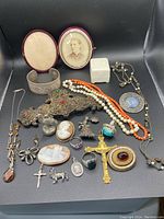 Overhead view of entire jewelry assortment including rings, necklaces, pendants, brooches, bracelet, locket, cameo pieces and crucifix