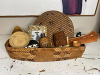 Shallow oval carrier-style basket filled with various items on a surface