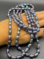 Close-up photo of the natural black baroque pearl necklace showing the iridescent colors and textured pearls.