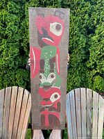 Full front view of entire canvas panel held between two chairs outdoors