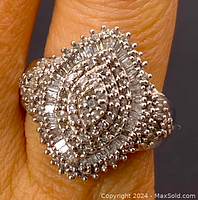 Close-up of ring on finger showing marquise diamond cluster top