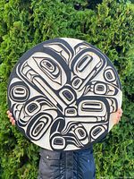 Front view of circular carved and painted wood plaque showing design and condition