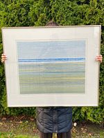 Person holding framed print outdoors showing full size and framing