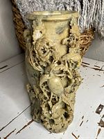 Front view of carved soapstone urn showing openwork floral and bird motif