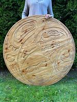 Front view of carved roundel held by person outdoors