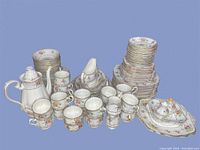 Full spread of all pieces showing stacks of plates, cups, teapot, gravy boat and spooner