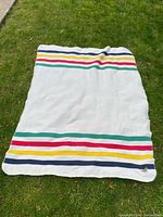 Full view of the HBC blanket spread on grass, showing the multicolor stripes and overall condition.