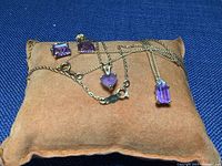 All five jewelry pieces displayed on suede pad