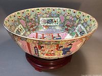 Side view of porcelain bowl seated on wooden stand, showing exterior figural and floral decoration