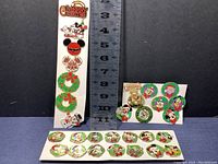 Full display of 29 Disney holiday-themed trading pins including some Limited Edition, many on boards with Christmas wreath backgrounds.
