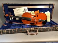 Full view of violin, bow, accessories and case