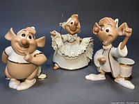 Front view of all three mice figurines on gray background