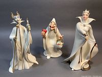 Group shot of three figurines on gray background