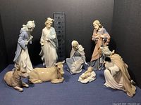 Group shot of all eight figurines with measuring scale