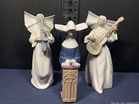 Three nun figurines front view with ruler background