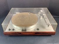 Front view with closed Lexan dust cover showing wood base and silver top plate.