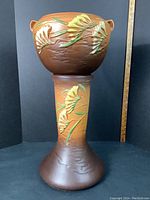 Assembled two-piece planter showing brown matte glaze and freesia design