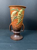 Front view of vase showing relief freesia design and two-handled profile