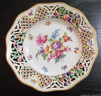 Full view of antique Dresden Schumann Bavaria reticulated plate with floral center and lattice pierced border with floral and leaf accents.