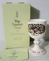 Photo of the goblet with original box and paper insert showing branding and design.