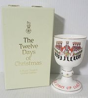 Photo of the closed original box with gold lettering: 'The Twelve Days of Christmas, A Royal Doulton Limited Edition' and the goblet standing next to it.