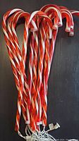 Photo showing 10 red and white striped electric candy cane decorations bundled together with cords visible