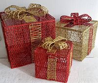 Three metal wire mesh decorative gift boxes with red and gold finishes and gold bows, placed on white surface.