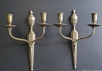 Pair of silver Art Deco style wall sconces photographed against dark background, showing both sconces together highlighting symmetric design and condition.