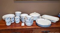 Lenox Chinastone poppies on blue china pieces including stacks of mugs, small bowls, dinner and salad plates, covered casserole dish and serving platter, plus Target Home plain white bowls.