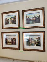 Four framed prints displayed on wall showing detailed impressionistic architectural scenes with water reflections