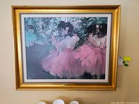 Framed print showing dancers in pink tutus, floral background, and gold ornate frame from front angle.