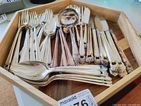 Photo of Rogers Bros silver plated flatware set in wooden box, showing forks, spoons, knives, and serving utensils with 1847 Eternally Yours floral handle pattern.