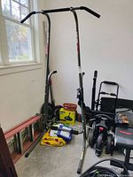 Image of Stamina PT 1690 power tower exercise equipment in a garage, surrounded by other items like ladder and boxes, showing full frame with pull-up bar and dip station.