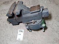 Full view of the Craftsman bench vise showing the vise body, jaw, adjustment handle, and mounting base on a concrete floor.