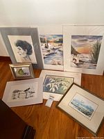 Photo of all artworks grouped on floor showing variety of paintings and drawings including portrait, landscapes, floral, and ink drawing.