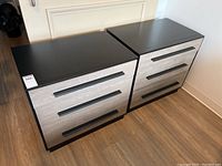 Two matching nightstands side by side showing the front with drawer handles and wood-textured fronts