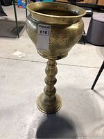 Full view of the brass plant stand showing the rounded bowl with etched detail and pedestal base.