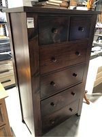 Front view of dark pine chest showing all six drawers and wooden knobs