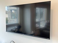 Full view of Hisense 43 inch TV mounted on wall.